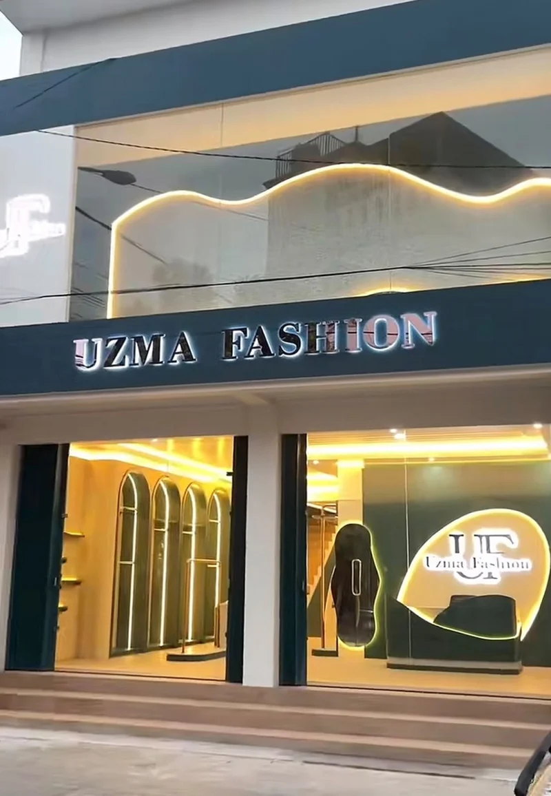 Tampak depan toko Uzma Fashion dengan papan nama dan pencahayaan hangat
